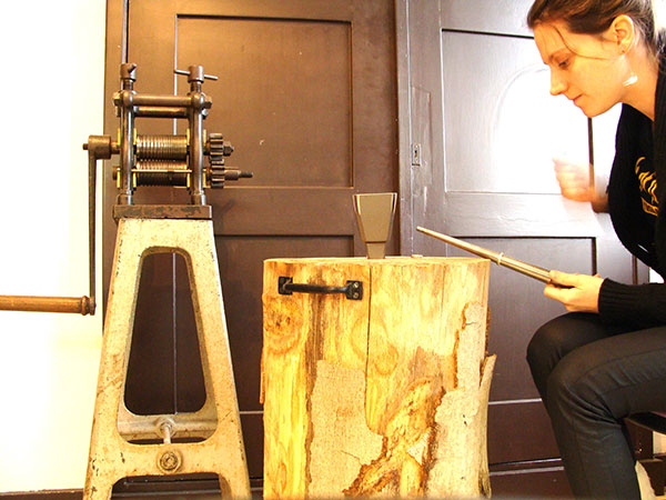 Carla aan het werk bij de walsmachine in haar atelier